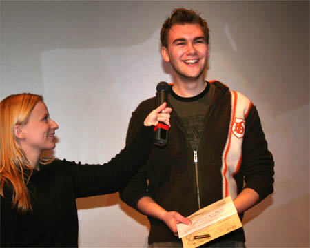 der Filmemacher mit Urkunde in der Hand wird von der Moderatorin interviewt ©Parabol