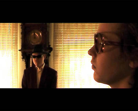 im Hintergrund steht ein Mafioso vor einer Standuhr, vorne gro von der Seite der Gast ©MK Films