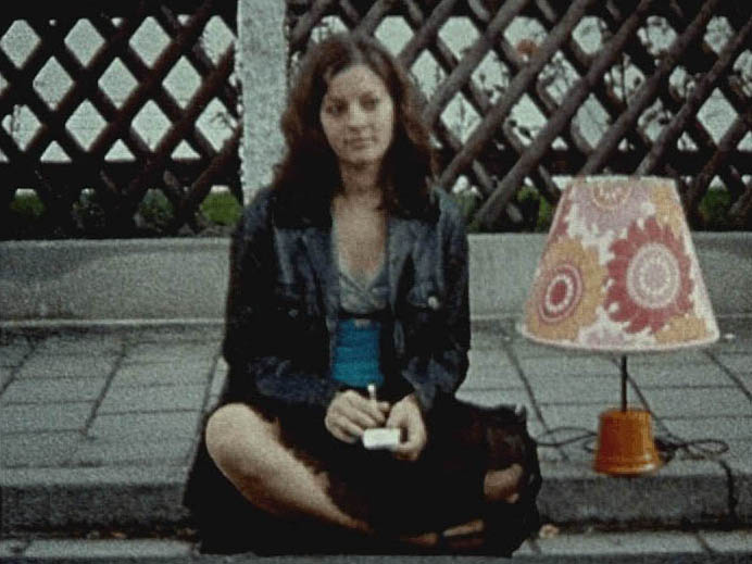 Junge Frau sitzt mit Nachttischlampe am Straßenrand ©Marlene Denningmann Junge Frau sitzt mit Nachttischlampe am Straßenrand ©Marlene Denningmann